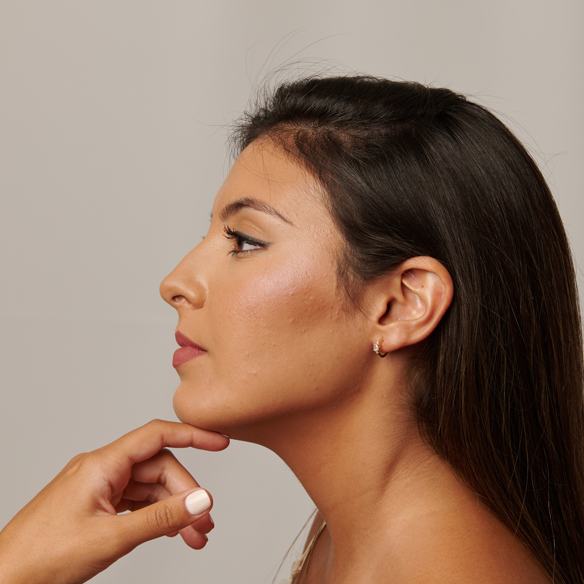 Aro de oro con piedra color blanco esmeralda en oreja de modelo