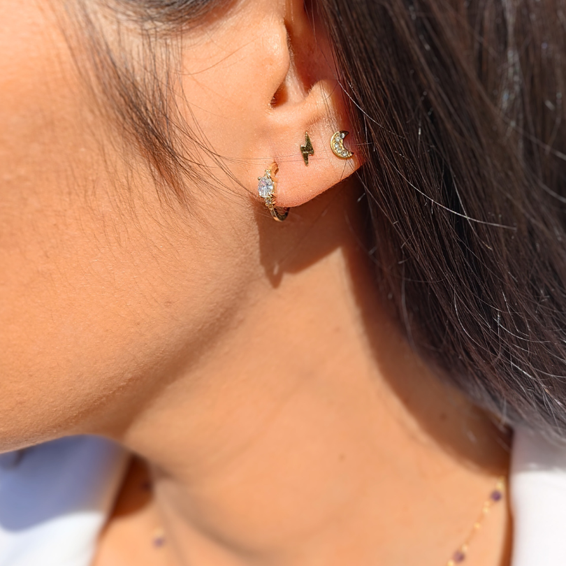 Foto de producto con fondo blanco. Pendiente de medio aro en oro amarillo 18K con circonita roja